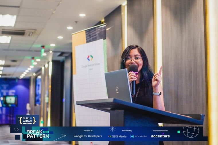 Rheanne presenting from a laptop at a lectern during a Google Developers community event.