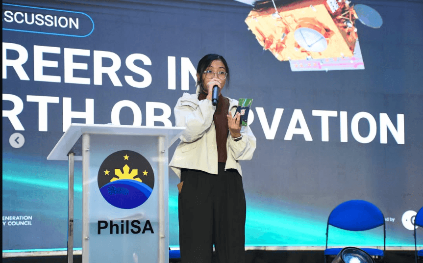 Rheanne speaking with a handheld microphone at a PhilSA panel titled &ldquo;Careers in Earth Observation&rdquo;.